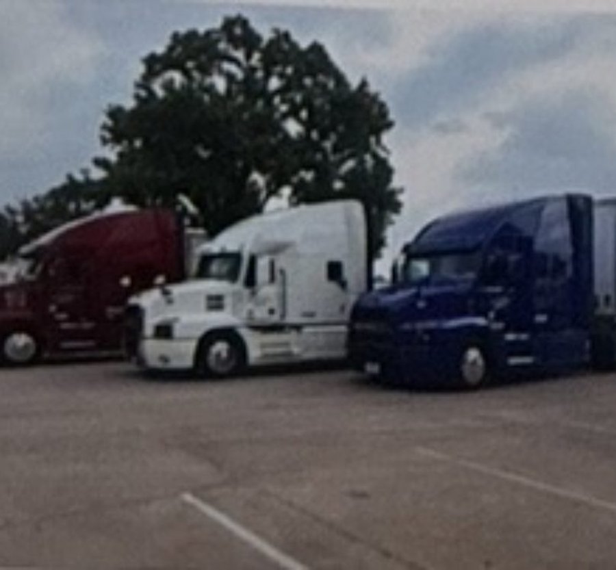 Red, white, and blue Edwards Transport Services Mack tractors parked side by side